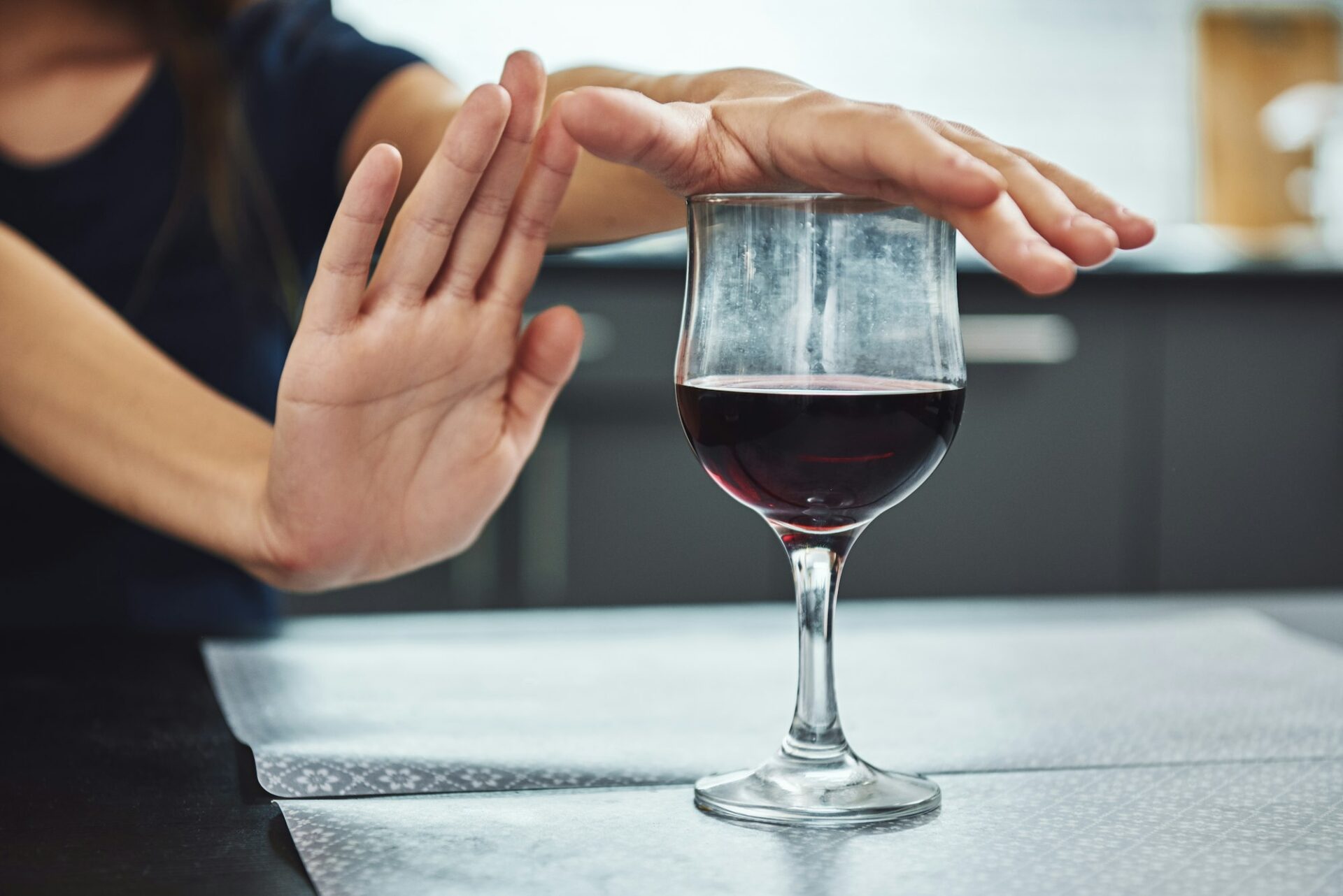 A small step toward recovery is giant progress. Addicted woman refuses to drink a glass of red wine